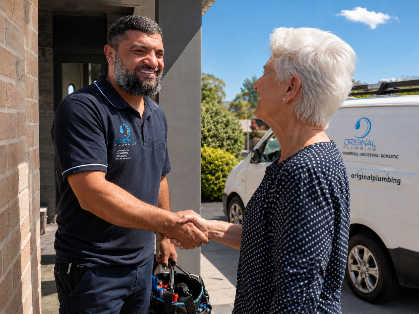 Mustafa from Original Plumbing shaking hands with a happy customer